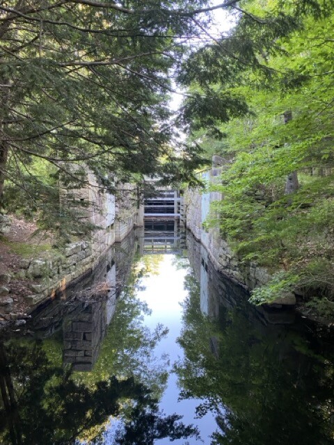 Lock in Shubie Park - trees at the side of the canal, stone walls and the lock gate.