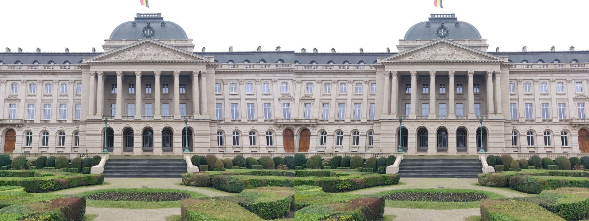 Stereoscopic view of the Royal Palace, Brussels. The building is face-on, with a prominent colonnaded portico and a domed roof, atop which flies the Belgian tricolour flag. Meticulously trimmed hedges and bushes adorn the lawns around the building.