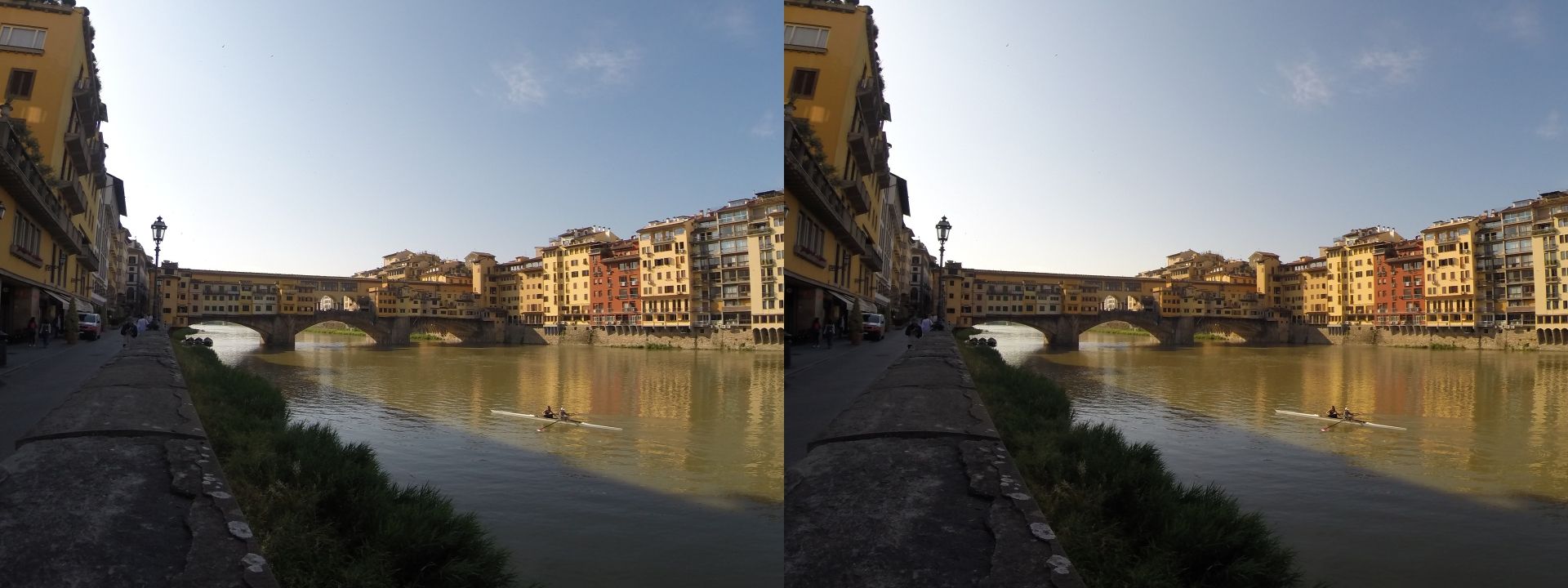 Cross-view stereoscopic image taken in the early morning in Florence, standing on the north bank of the Arno river. The built-up Old Bridge (Ponte Vecchio) with three stone arches is in the centre; the low sun illuminates the houses in the Oltrarno neighbourhood on the south bank. The north bank is still shaded, the river is calm. Two rowers in a shell pull upstream as part of their training routine, and are about to pass under the northern arch of the bridge. Hardly any people are yet visible on the sidewalk, which is usually busy and crowded with people in the middle of the day.