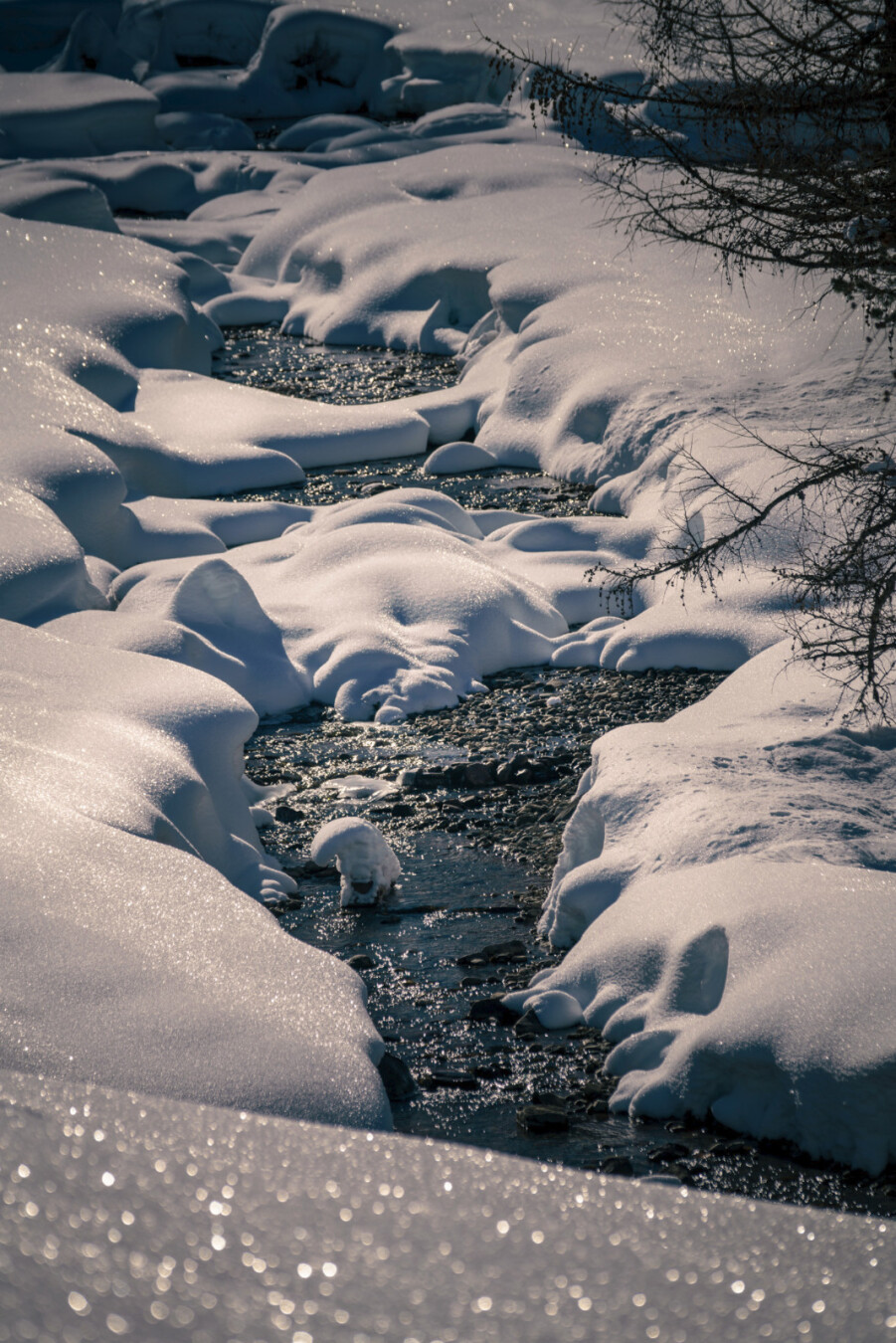A mountain stream. Both sides are covered with snow.