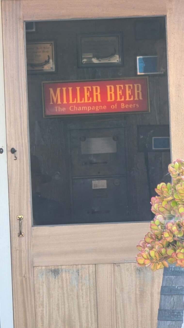 MILLER BEER - THE CHAMPAGNE OF BEERS sign, though a doorway