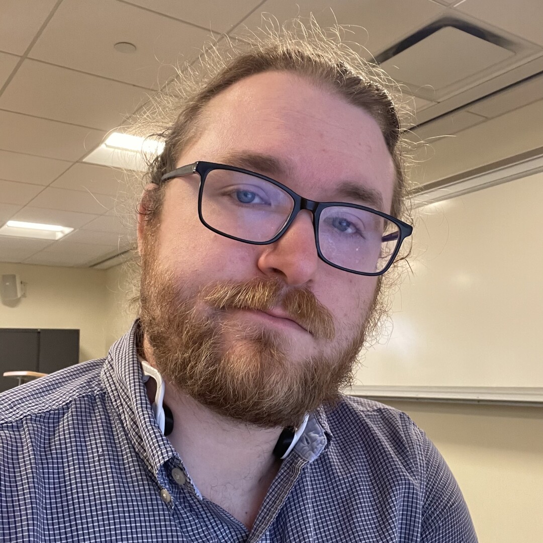 Bearded man in glasses smiling at the camera.