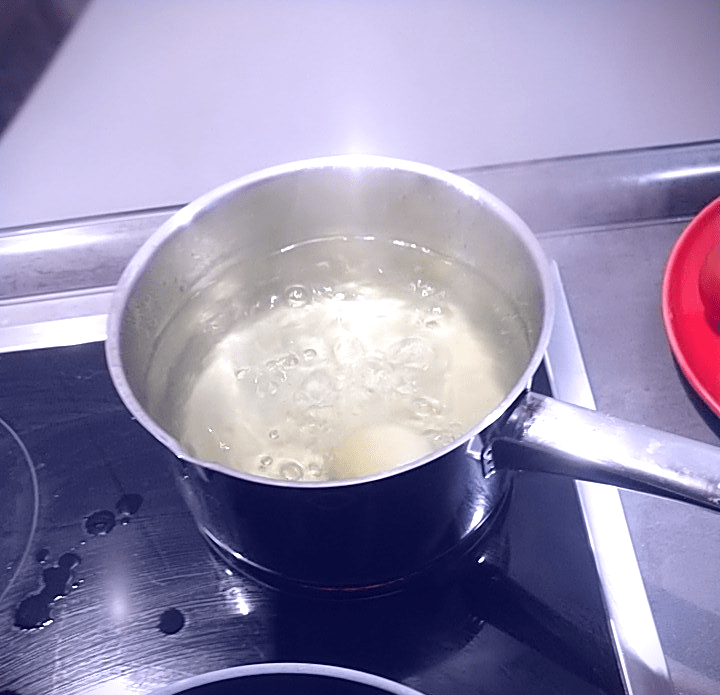 boiling onion in small metal pot on stove