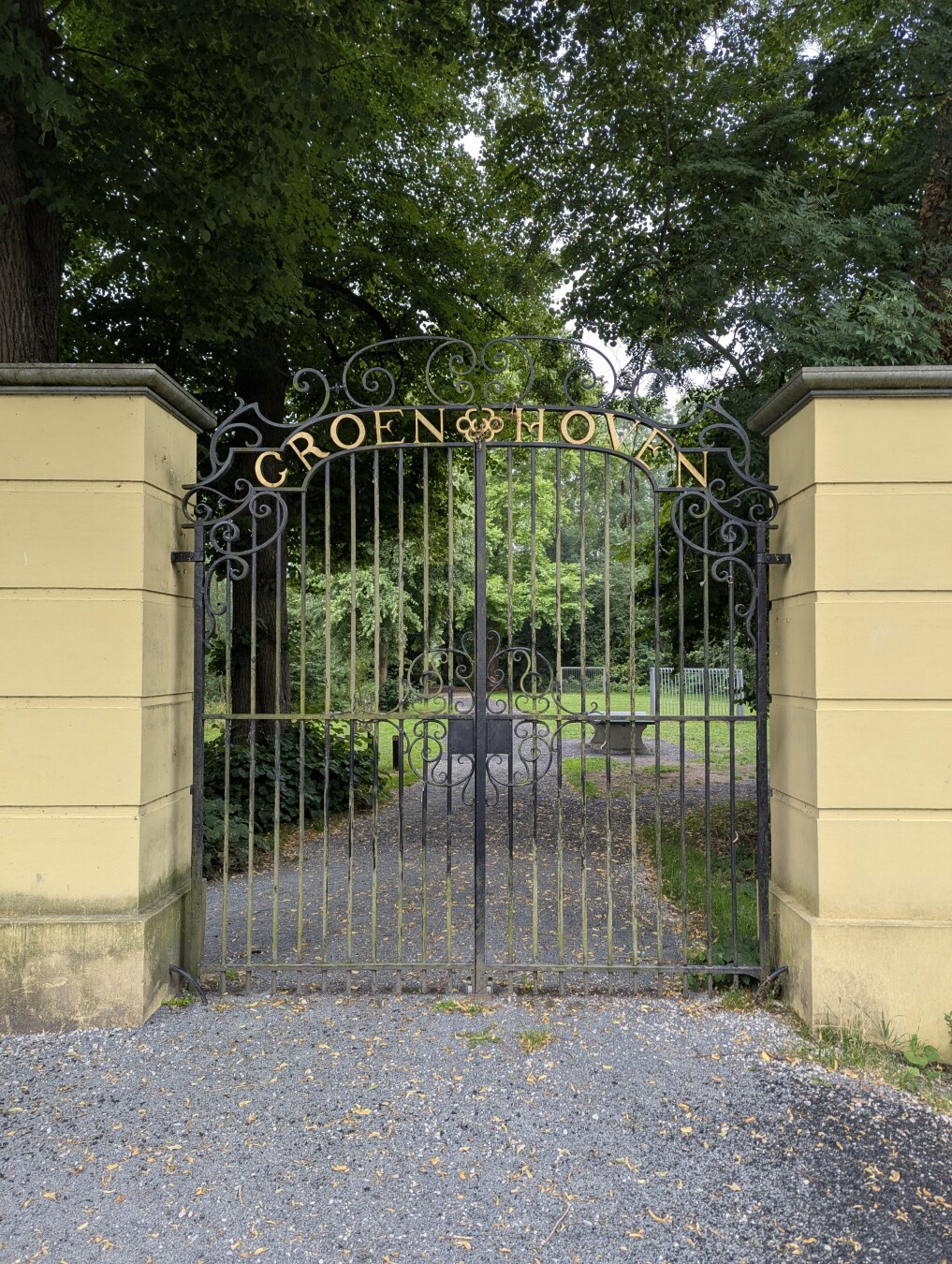 A decorative black wrought-iron gate with the words