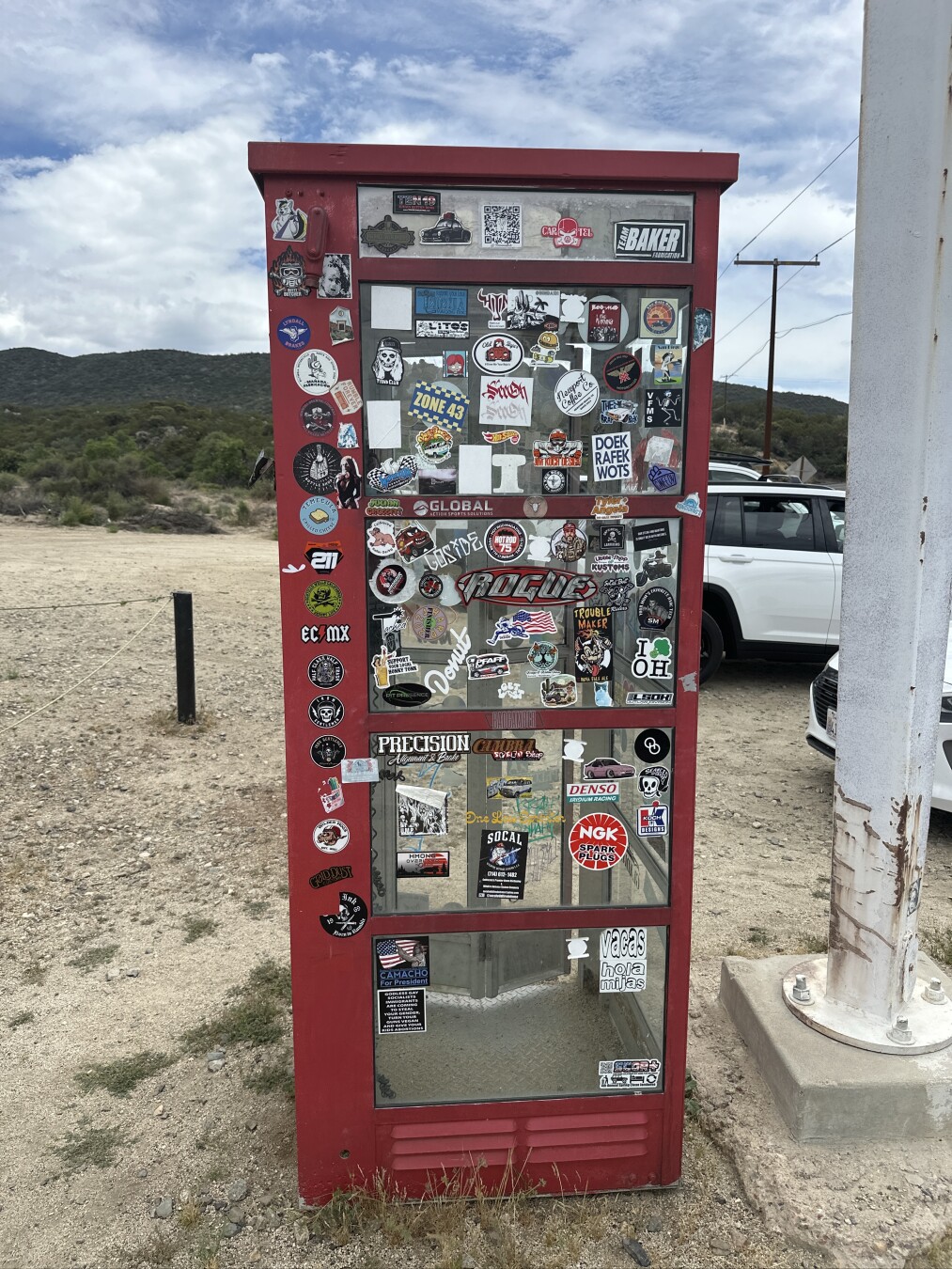 A red phone booth covered with stickers