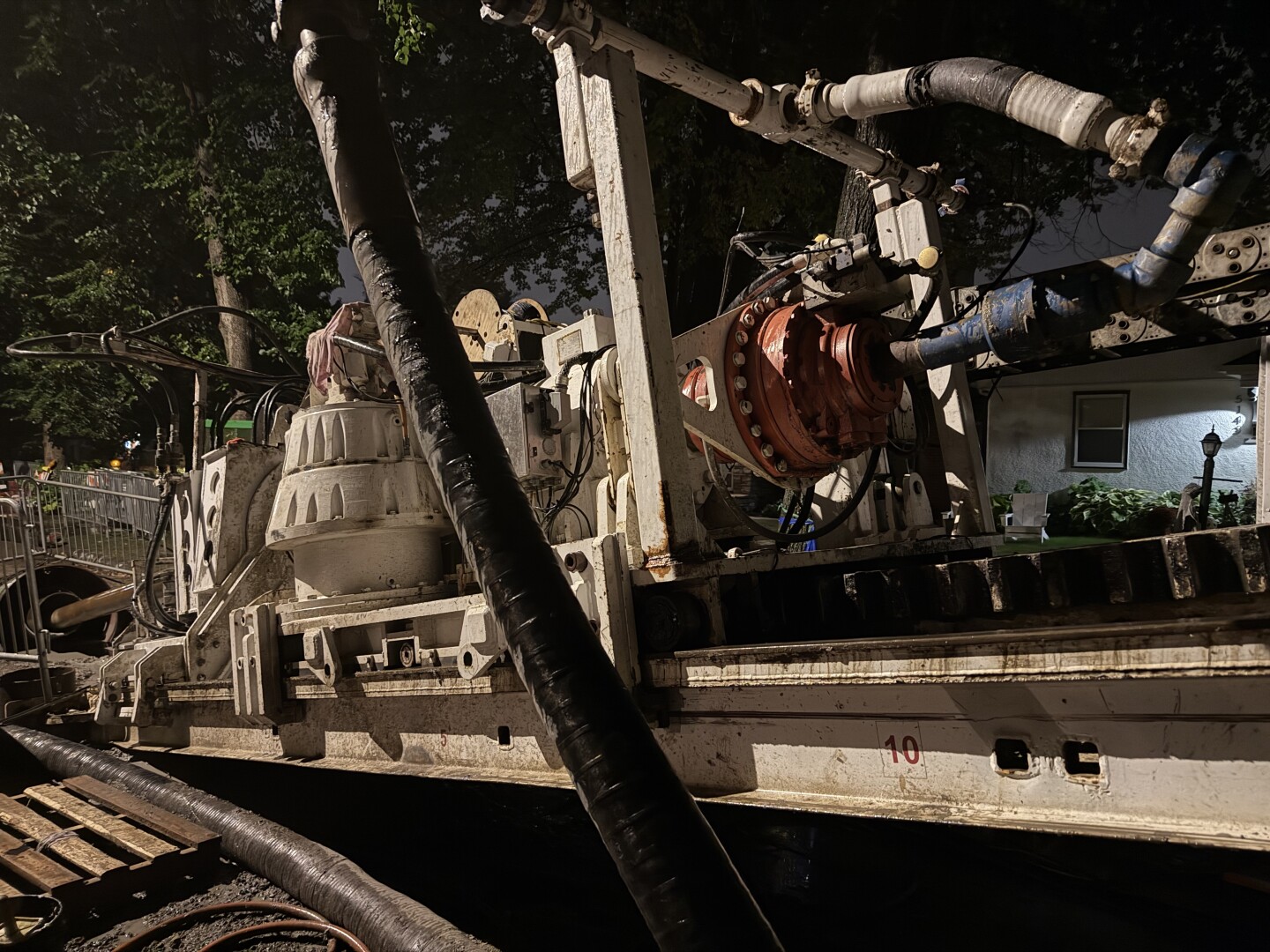 photo of a construction machine on a residential street at night