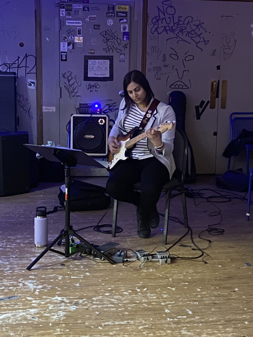 Abhilasha Chebolu playing guitar at an album release performance for Turtle Boat’s “Fear is Heavy, I’ve Got Plans…”