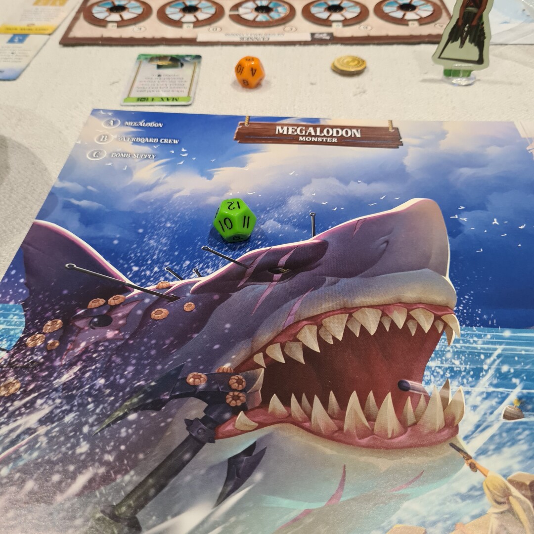 image from board game book showing a MEGALODON, giant shark leaping from the water. a green d12 dice is on the book.