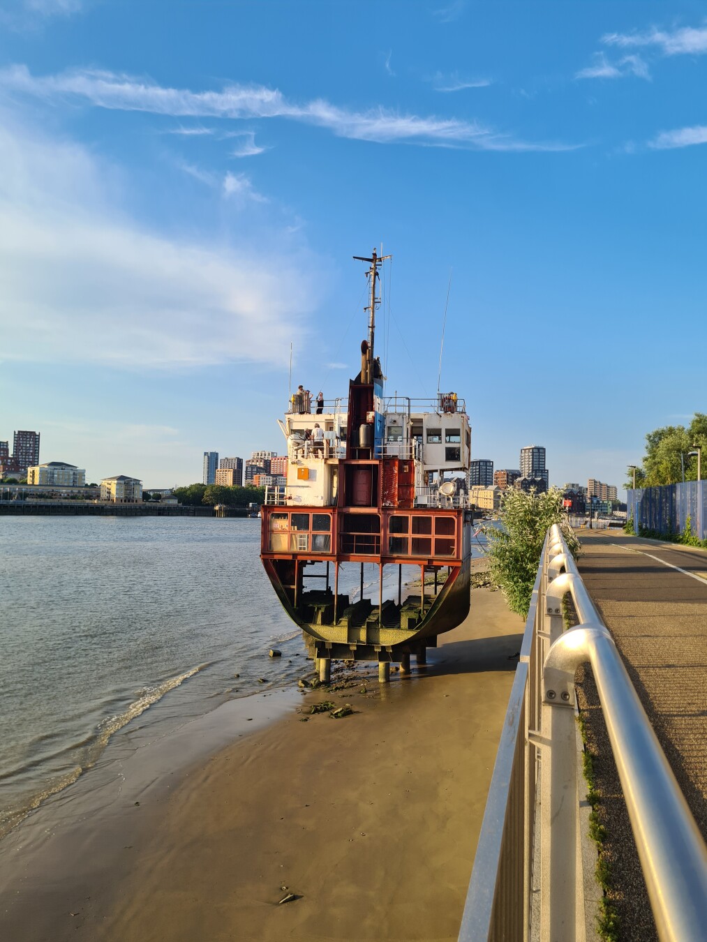 photo of "a slice of reality" - sculpture by Richard Wilson which is a segment of an oil tanker anchored to the Thames bank. as it is low tide you can see inside the ship.