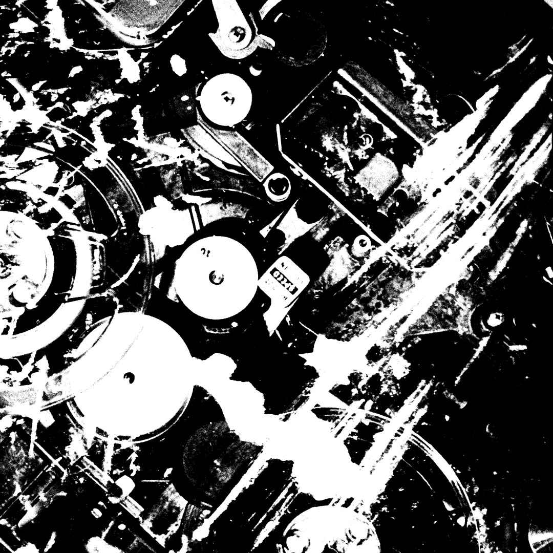 A stark black and white image of an old reel to reel tape machine mechanism,