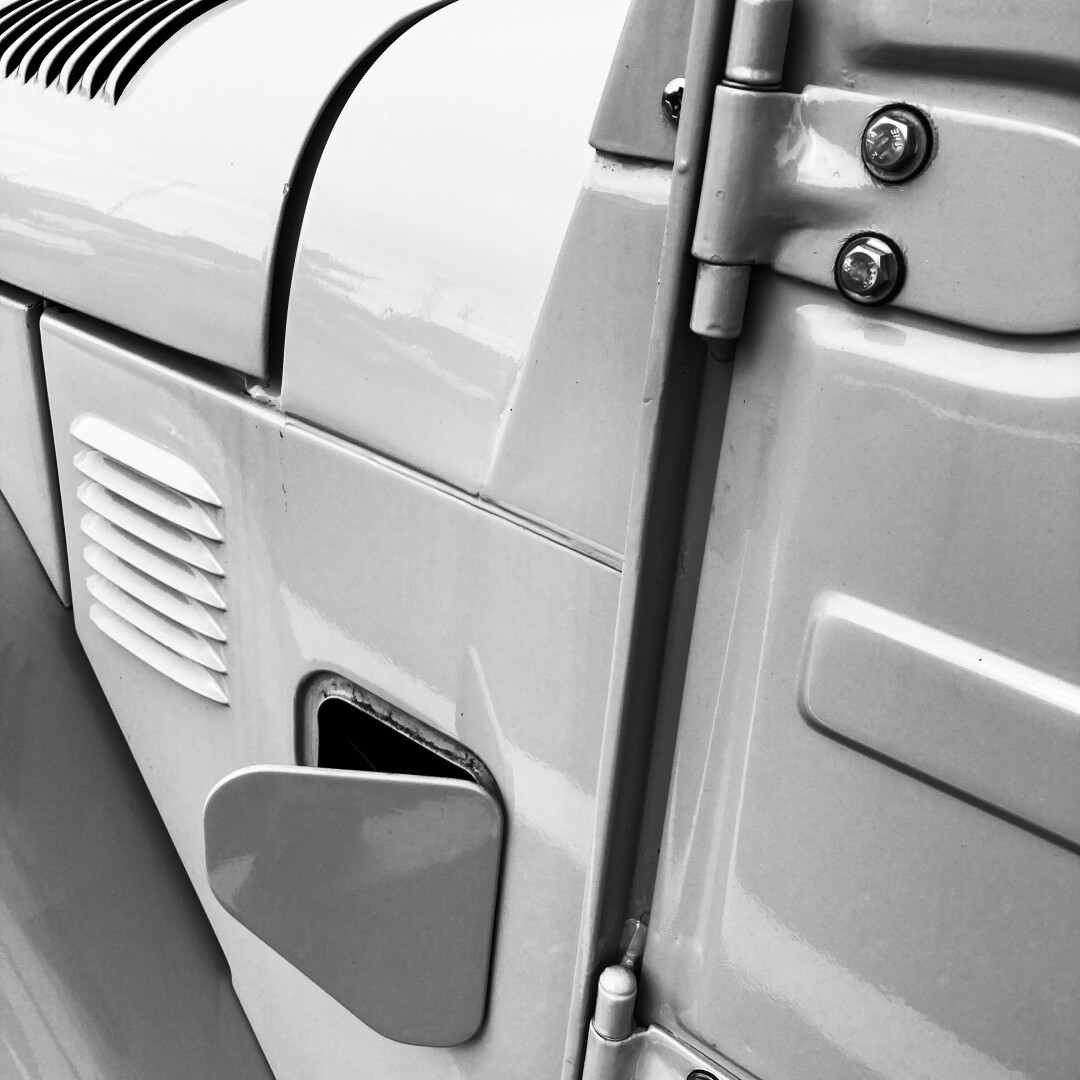 black and white photograph of details of a vintage Toyota Land Cruiser, showing vents, seams, and embossed metal