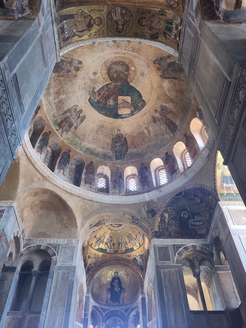 The ceiling of the main church dome, showing more rich paintings of Jesus as a central figure surrounded by angels and saints. Every pillar and smaller dome below the main dome is similarly richly decorated, including a lot of gold leaf.