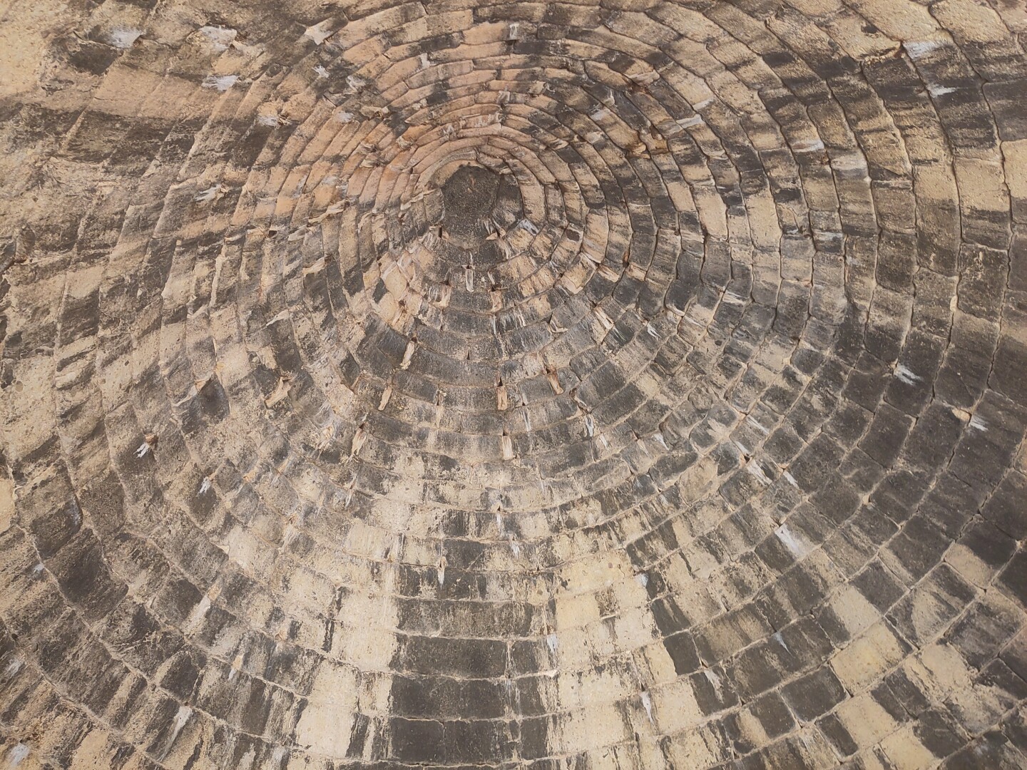 The inside view of an incredibly high dome ceiling of the Treasury of Atreus or Tomb of Agamemnon as a so-called beehive tomb. While hard to see the scale, 2 to 3 rows of stones together was about a person's size tall.