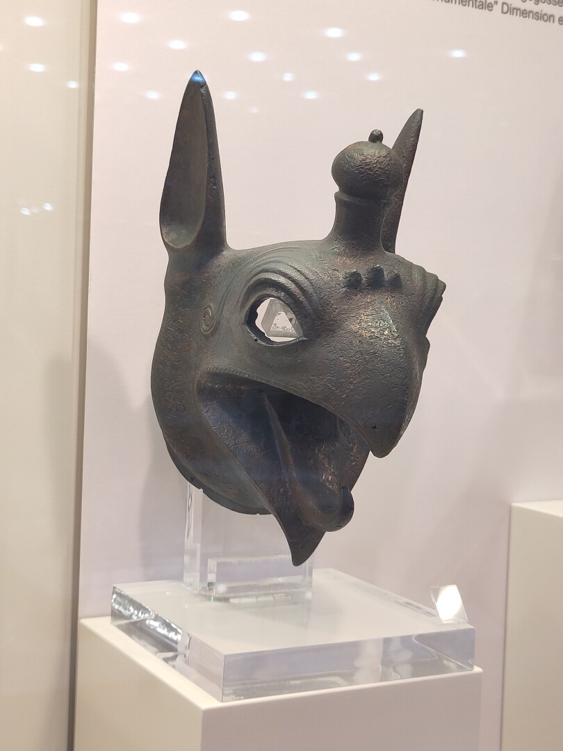 Close-up of a bronze statue of a griffon head, which was first cast then hammered with lots of little pattern details. It really reminded me of Assan in Dragon Age: The Veilguard!