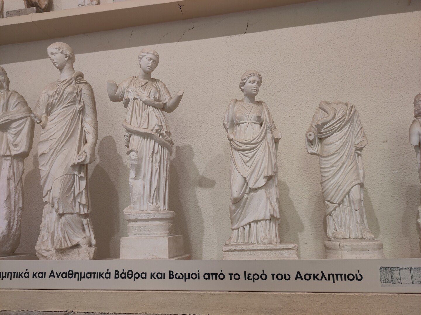 Several plaster casts of smaller statues of Hygieia, Asklepios' daughter and goddess of hygiene. She's depicted here just with a snake, but her symbol is a bowl with a snake wrapped around its stem. This symbol is still used today for pharmacology.