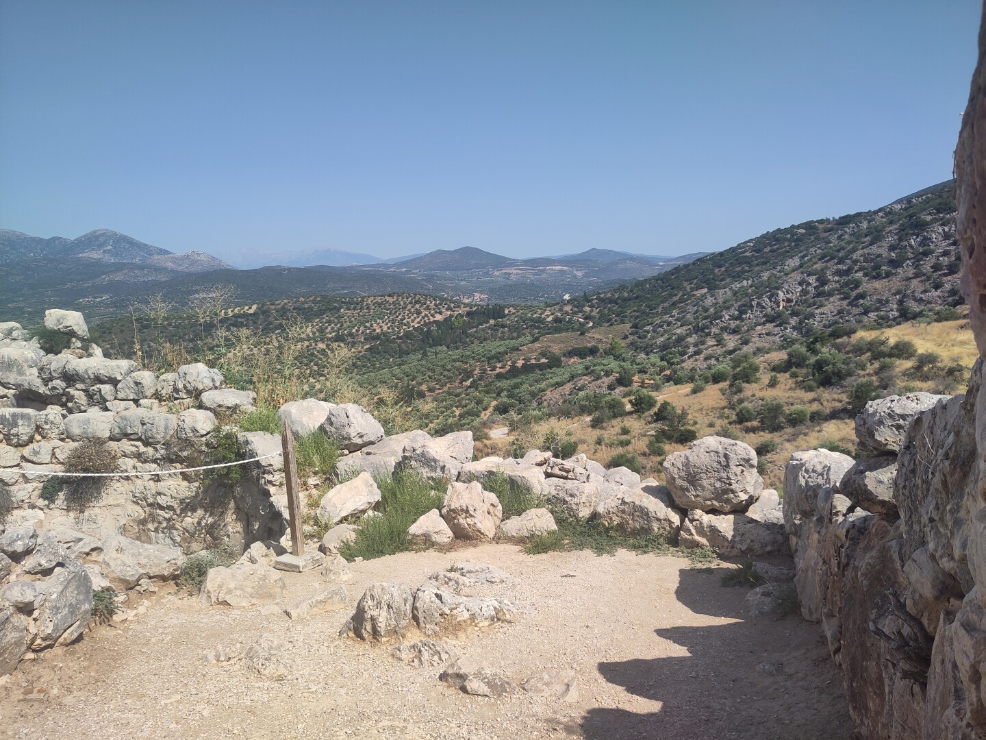 A beautiful view from the fortress ruins, some low stone walls running along the foreground  and a stretch of hills dotted with green trees in the background. This wasn't even the best view, but it already demonstrates the tactical positioning of the fortress.