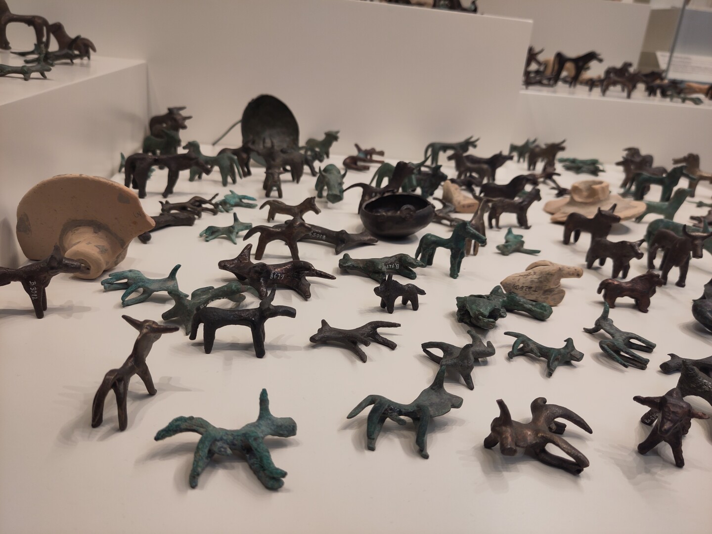 A bunch of little bronze animal figurines strewn around in various positions: all kinds of mammals like horses, bulls, deer, dogs? It's hard to tell, but they're all silly cute.