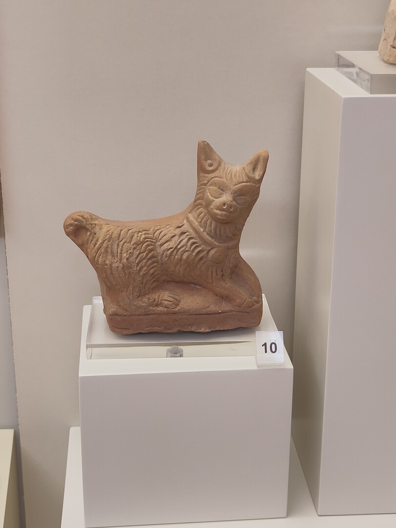 A tiny clay statue of a cat laying. Very simple and silly looking, so cute!