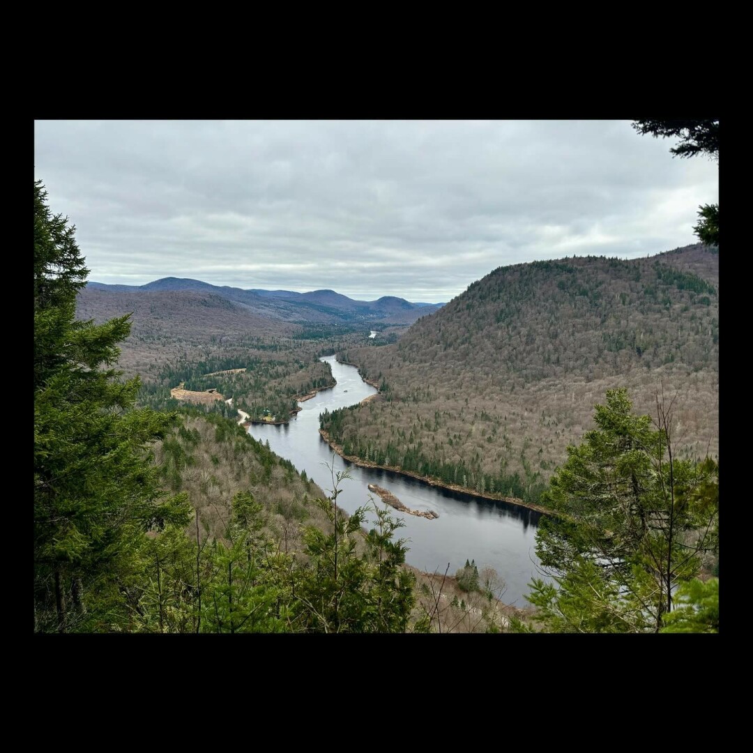 River going through mountains, no leaves on trees.